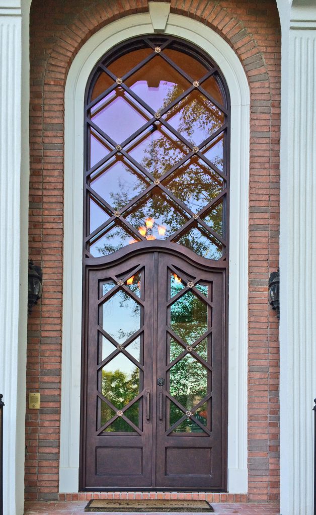 Very tall arched custom iron door in Atlanta with very tall arched transom attached